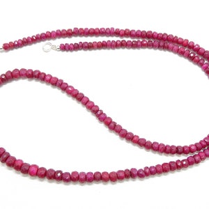 Puede incluir: Un collar largo hecho de pequeñas cuentas de rubí facetadas. El collar está enhebrado en una cadena de plata y tiene un cierre de mosquetón.