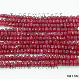 May include: A strand of ruby red gemstone beads, approximately 4mm in size, strung on silver wire. The beads are smooth and polished, with a slight variation in shape and size. The strand is approximately 16 inches long.