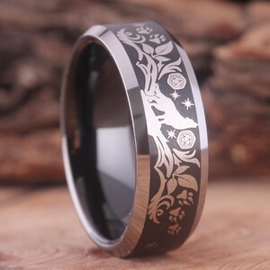 May include: A black tungsten carbide ring with a silver wolf, paw prints, and floral design engraved on the band.