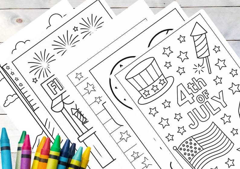 May include: A stack of black and white coloring pages with patriotic themes, including fireworks, stars, and an American flag. Crayons in various colors are in the foreground, ready for use. The pages are designed for the 4th of July.