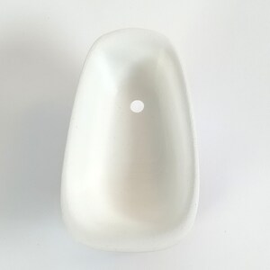 May include: White ceramic bathtub with a round drain hole. The bathtub is small and appears to be a miniature version of a real bathtub.