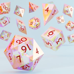 Puede incluir: Un conjunto de dados de múltiples caras en varias formas geométricas, flotando sobre un fondo azul claro. Los dados son translúcidos con un diseño abstracto colorido y números rojos. Ideal para juegos de mesa.