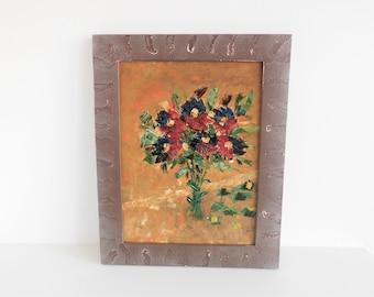 May include: A framed painting of a bouquet of red and blue flowers with green leaves on a gold background.