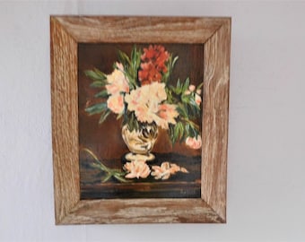 May include: A framed oil painting of a still life featuring a bouquet of pink and red flowers in a silver vase on a dark brown table.