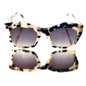 May include: A white ceramic mug with a black handle and the text "But First, Coffee" in a handwritten style. The mug is on a white surface. The mug is approximately 4 inches tall.