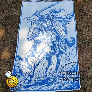 May include: A rectangular crochet blanket featuring a blue and white graphic design of a knight on horseback holding a sword and a shield with a lion emblem. The text CROCHET PATTERN is printed in the bottom right corner of the textile piece.