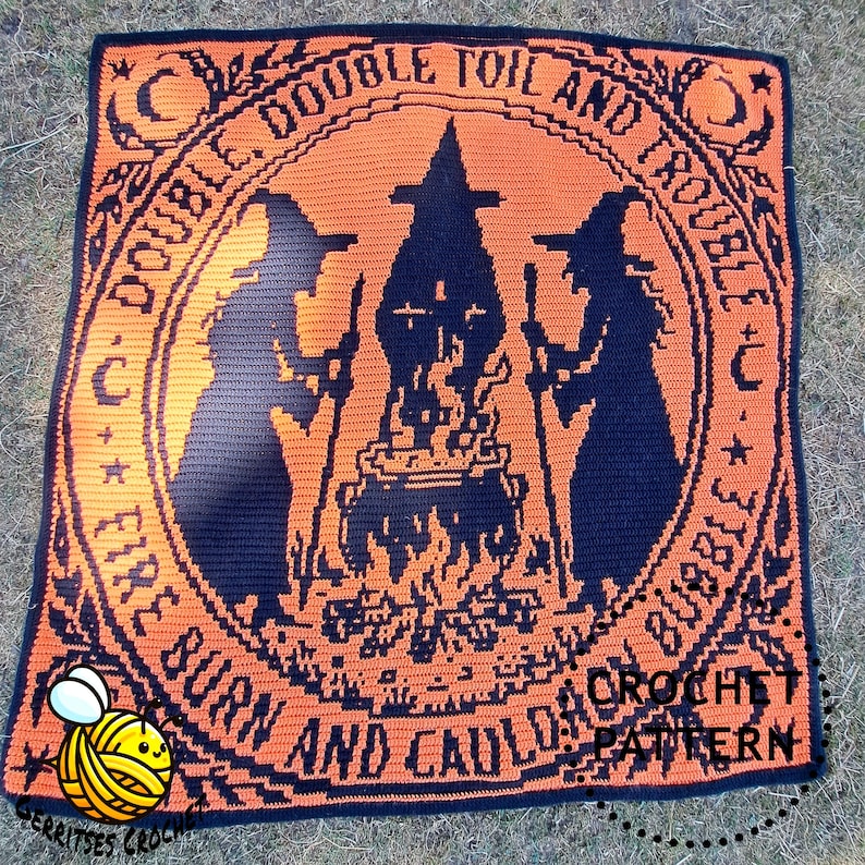 May include: A square crochet blanket featuring a black and orange design of two witches standing over a bubbling cauldron. The circular border contains the text Double, Double Toil and Trouble; Fire Burn and Cauldron Bubble. A small bee icon is present.