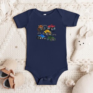 Puede incluir: Body de beb&eacute; azul marino con un gr&aacute;fico colorido de cinco monster trucks. Los camiones son rojos, amarillos, azules, verdes y naranjas, cada uno con dise&ntilde;os &uacute;nicos. El body tiene mangas cortas y cierres de presi&oacute;n.