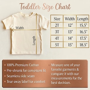 Puede incluir: Una camiseta crema para ni&ntilde;os peque&ntilde;os con una tabla de tallas. La tabla enumera las tallas 2T a 5T, con las medidas de ancho y largo en pulgadas. Texto adicional destaca caracter&iacute;sticas como 100% algod&oacute;n premium.