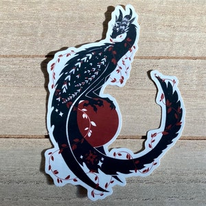 May include: Black and white silhouette of a dragon curled around a red circle with vines. The dragon has a detailed design with scales and stars.