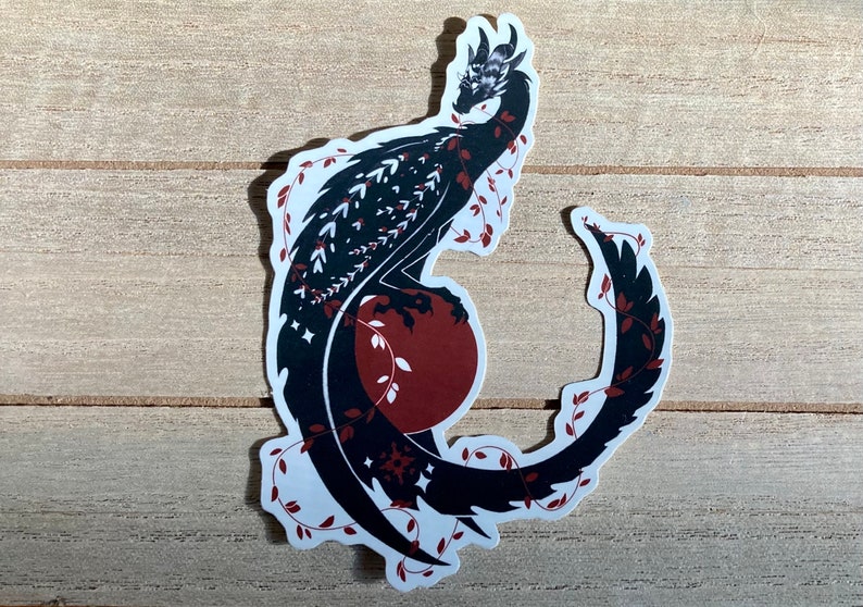 May include: Black and white silhouette of a dragon curled around a red circle with vines. The dragon has a detailed design with scales and stars.