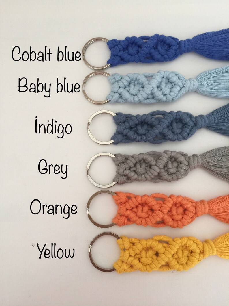 May include: Six keychains with silver key rings and tassels. The keychains are made of macrame cord in the following colors: cobalt blue, baby blue, indigo, grey, orange, and yellow.