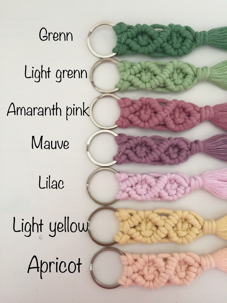 May include: Seven keychains with different colored macrame tassels. The colors are green, light green, amaranth pink, mauve, lilac, light yellow, and apricot. Each keychain has a silver ring.