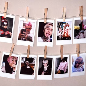 May include: A wall display of ten Polaroid photos featuring a young man with pink hair. The photos are hung on a string with clothespins.