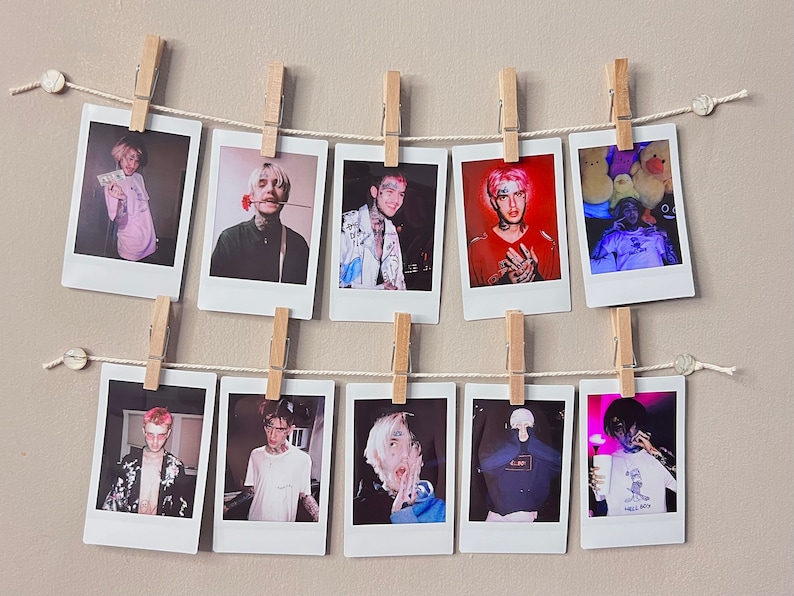 May include: A wall display of 10 Polaroid photos featuring a person with pink hair and various outfits. The photos are hung on a string with clothespins.