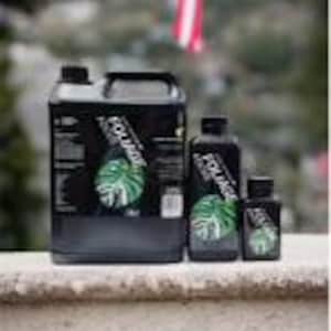 May include: Four bottles of plant fertilizer in different sizes. The bottles are black with a green leaf design and the word "Monstera" printed on the label.