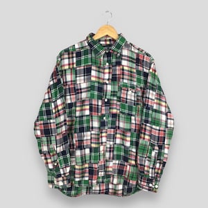 May include: A long-sleeved button-down shirt with a patchwork design. The shirt is made of a variety of plaid fabrics in shades of green, red, blue, and yellow.