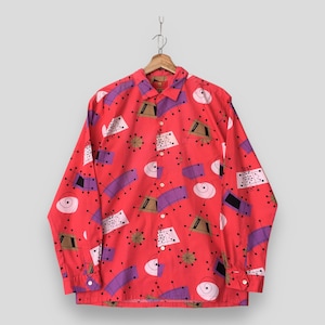May include: A long-sleeve button-down shirt in a vibrant red color featuring an all-over print of abstract geometric shapes, including purple rectangles, tan trapezoids, white circles, and black starburst lines, with a standard collar and cuffs.