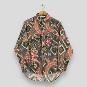 May include: A button-down shirt with a colorful geometric and floral pattern. The shirt features a collared neckline, two chest pockets, and long sleeves. The color palette includes shades of brown, green, orange, and purple.