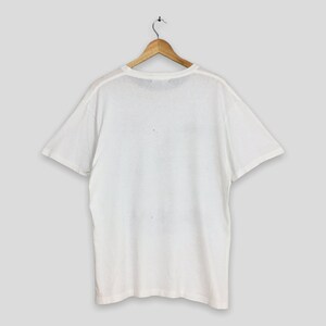 May include: White short-sleeved t-shirt with a crew neck.