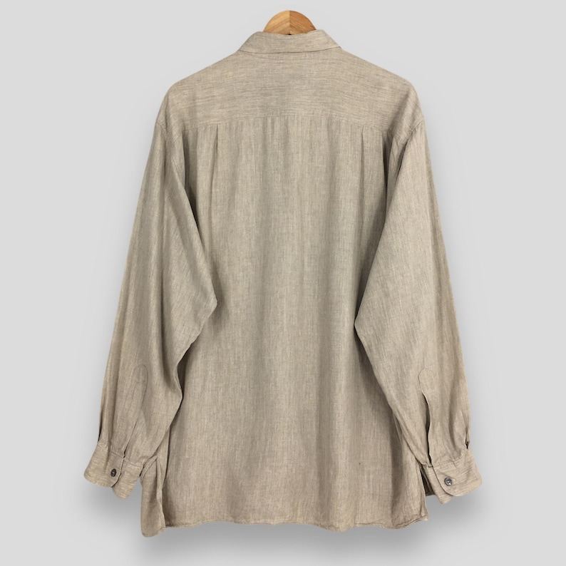 May include: A set of three ceramic mugs with a speckled, matte finish. The mugs are in shades of cream, light gray, and dark gray. Each mug has a simple, minimalist design and a rounded handle. Perfect for coffee or tea.