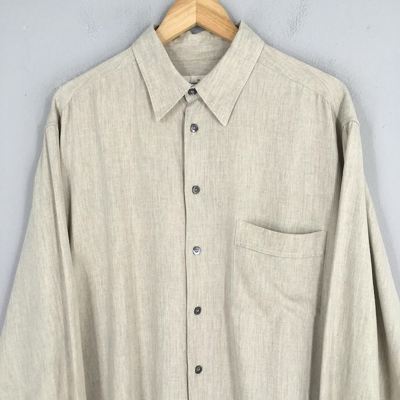 May include: A set of three ceramic mugs with a speckled, matte finish. The mugs are in shades of cream, light gray, and dark gray. Each mug has a simple, minimalist design, perfect for coffee or tea.