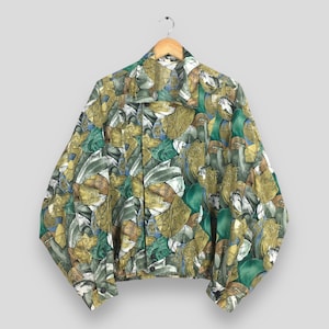 Może przedstawiać: Koszula z guzikami w kolorze zielonym, brązowym i złotym z wzorem. Koszula ma luźny krój i jest wykonana z lekkiej tkaniny.