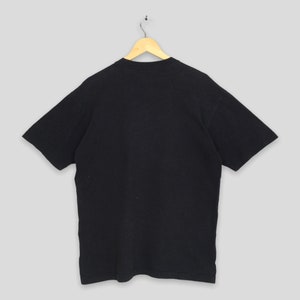 Może przedstawiać: Czarny T-shirt z kr&oacute;tkim rękawem i okrągłym dekoltem.