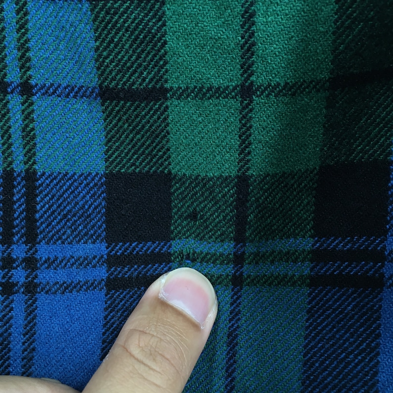 K&ouml;nnte beinhalten: Nahaufnahme eines blauen, gr&uuml;nen und schwarzen karierten Stoffes.