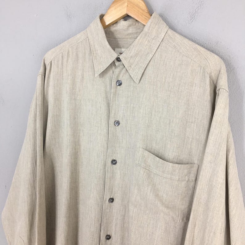 May include: A set of three ceramic mugs with a speckled, matte finish. The mugs are in shades of cream, light gray, and dark gray. Each mug has a simple, minimalist design, perfect for coffee or tea.