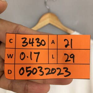 May include: Orange tag with black text. The tag has the letters C, W, and D in the left column. The numbers 3430, 0.17, and 05032023 are in the middle column. The letters A and L are in the right column. The numbers 21 and 29 are in the right column.