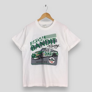 May include: White t-shirt featuring a green and white Skoal Bandit Racing car graphic. The design includes the number 33 and the text "The Bandit Back". The shirt is hanging on a wooden hanger.