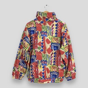 May include: A colorful, geometric patterned jacket with a high collar and a zipper closure. The jacket is made of a lightweight fabric and has a relaxed fit.