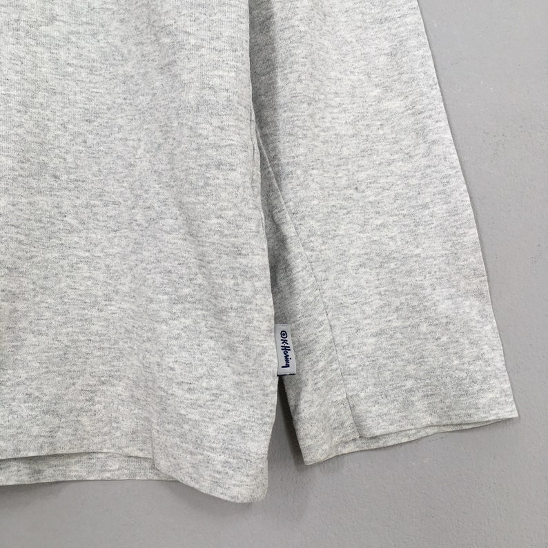 May include: Gray long-sleeve shirt with a small blue tag that says "G/FORE" on it.