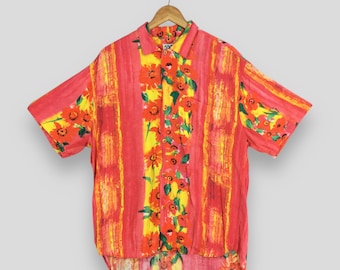 May include: A short-sleeved button-down shirt with a vibrant floral and striped pattern. The shirt features a red and yellow color scheme with vertical stripes and floral accents. The shirt is hanging on a wooden hanger.