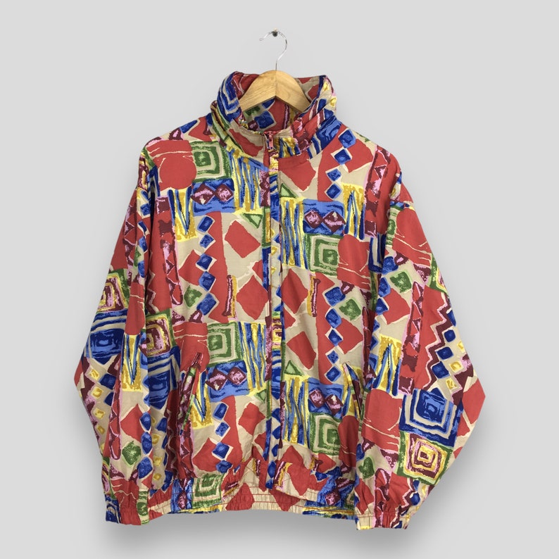 May include: A colorful, abstract patterned jacket with a zipper closure. The jacket is made of a lightweight fabric and has a relaxed fit.