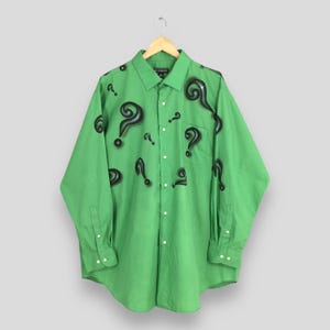 May include: A green long-sleeved button-down shirt with a pattern of black question marks.