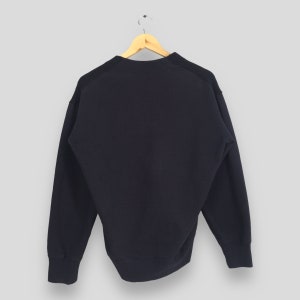 Puede incluir: Una sudadera de color azul marino oscuro con mangas largas y cuello redondo.