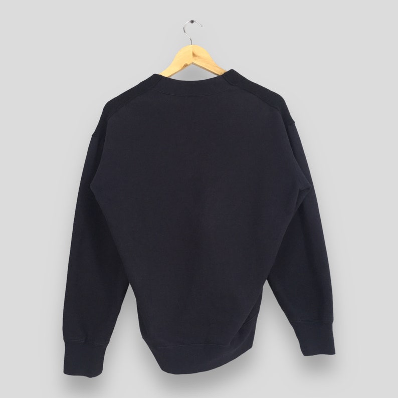 Puede incluir: Una sudadera de color azul marino oscuro con mangas largas y cuello redondo.