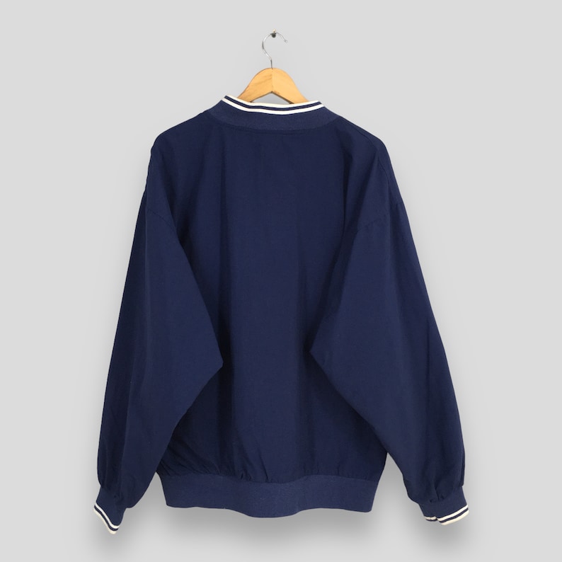 May include: A navy blue windbreaker jacket with white trim around the collar and cuffs.