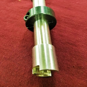 May include: A silver metal tool with a black ring and a knurled handle. The ring has the number "3/8" engraved on it.