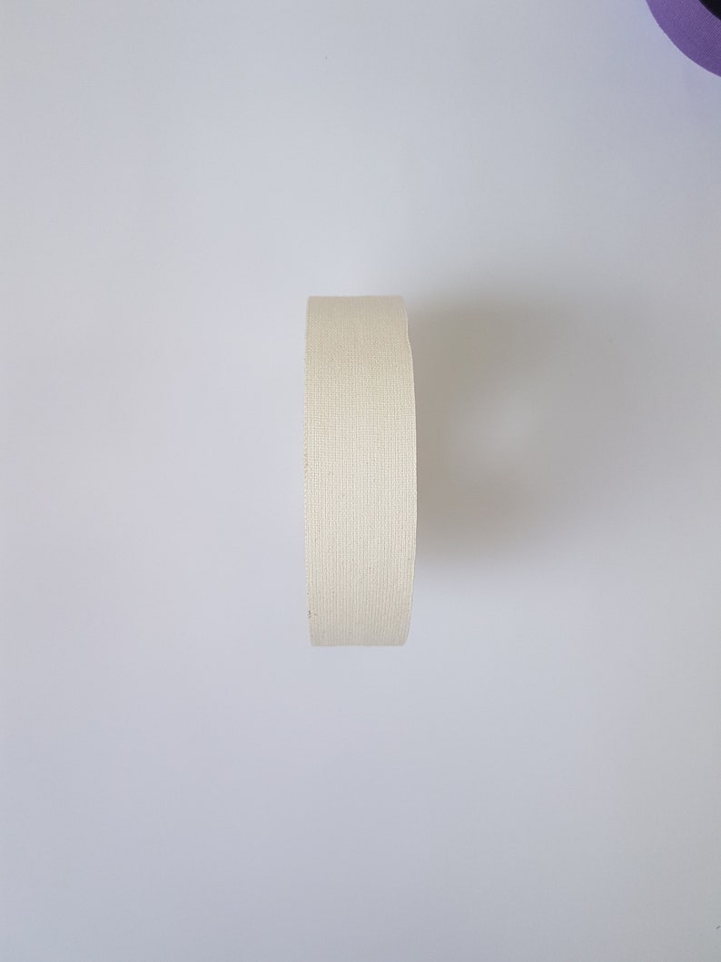 May include: A roll of white athletic tape, often used for sports injuries.
