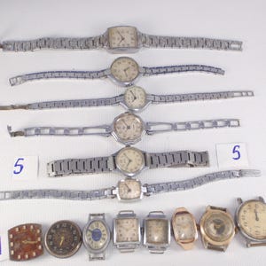 May include: A collection of vintage wristwatches with silver-tone metal bands and various face designs. Some watches have rectangular or square faces, while others are round. The image includes watches with different styles of watch faces.