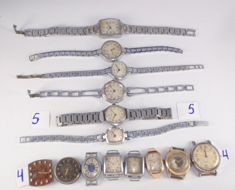 May include: A collection of vintage wristwatches with silver-tone metal bands and various face designs. Some watches have rectangular or square faces, while others are round. The image includes watches with different styles of watch faces.