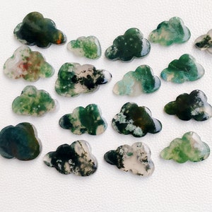 Pode incluir: Uma coleção de 16 cabochões de ágata em forma de nuvem de cor verde, branca e marrom. Os cabochões são polidos e têm uma variedade de padrões e texturas.
