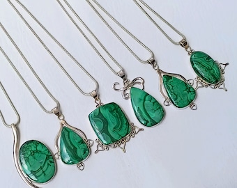 Pode incluir: Cinco colares de prata com pingentes de pedra de malaquita verde. Cada pingente tem um design único e é engastado em prata.