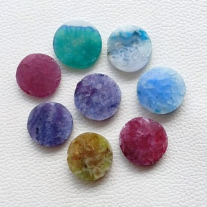 May include: Eight round agate slices in various colors, including green, blue, pink, purple, and brown. The agate slices have a natural, crystalline texture.