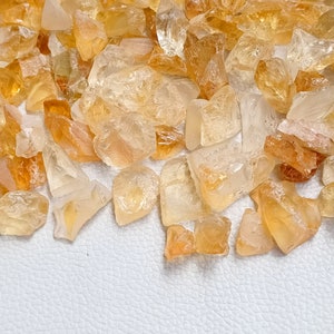 May include: A pile of small, rough, translucent, yellow-orange citrine crystals.