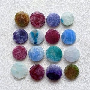 May include: Assortment of 15 round agate slices in various colors, including blue, green, purple, pink, and brown. Each slice has a unique pattern and texture.