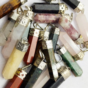 May include: A collection of various gemstone pendants with silver-toned metal caps. The pendants are in different shapes and colours, including clear, pink, green, brown, and black.
